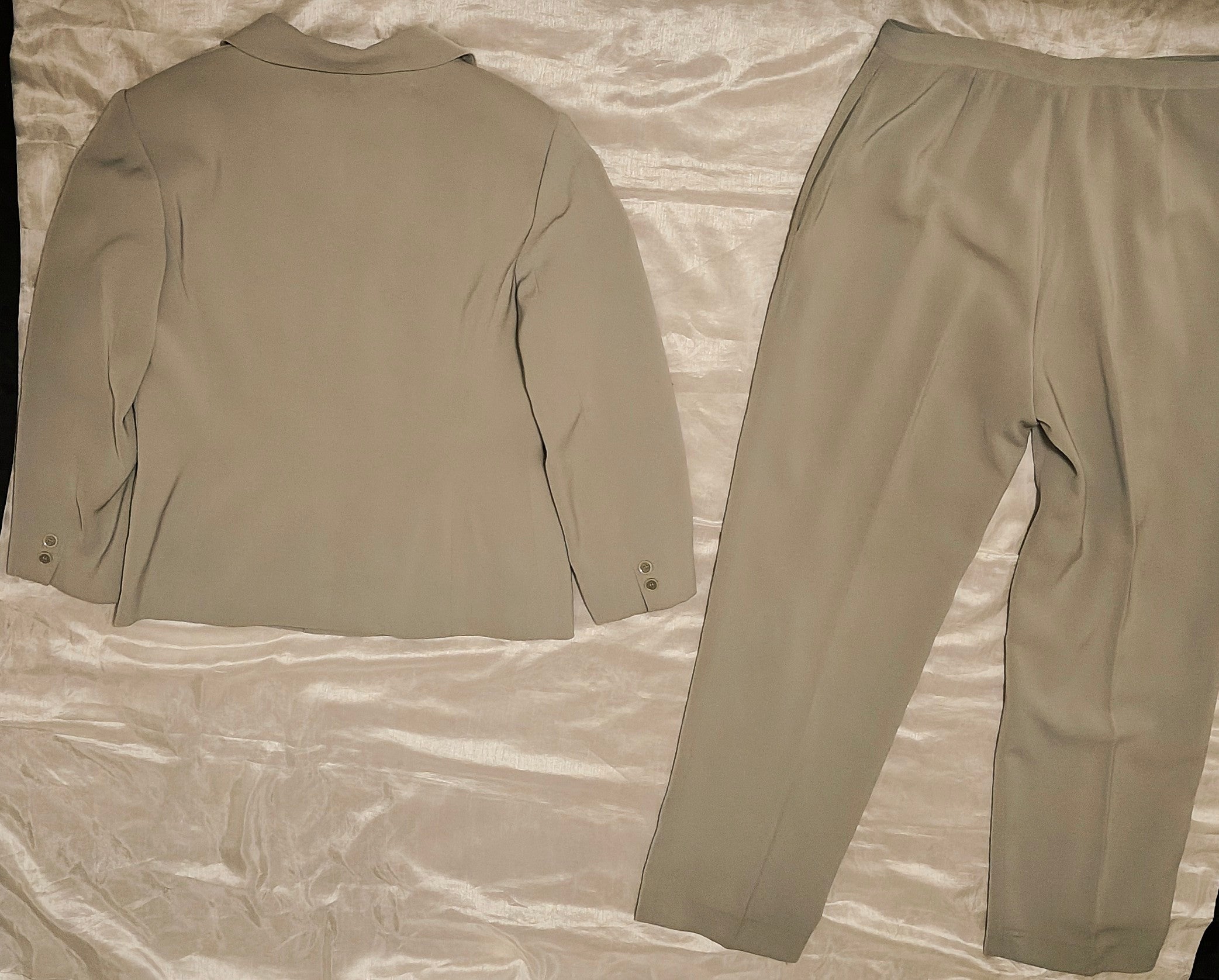 Beige suit jacket and pants on a textured fabric background