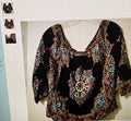 Black top with colorful pattern on a white background