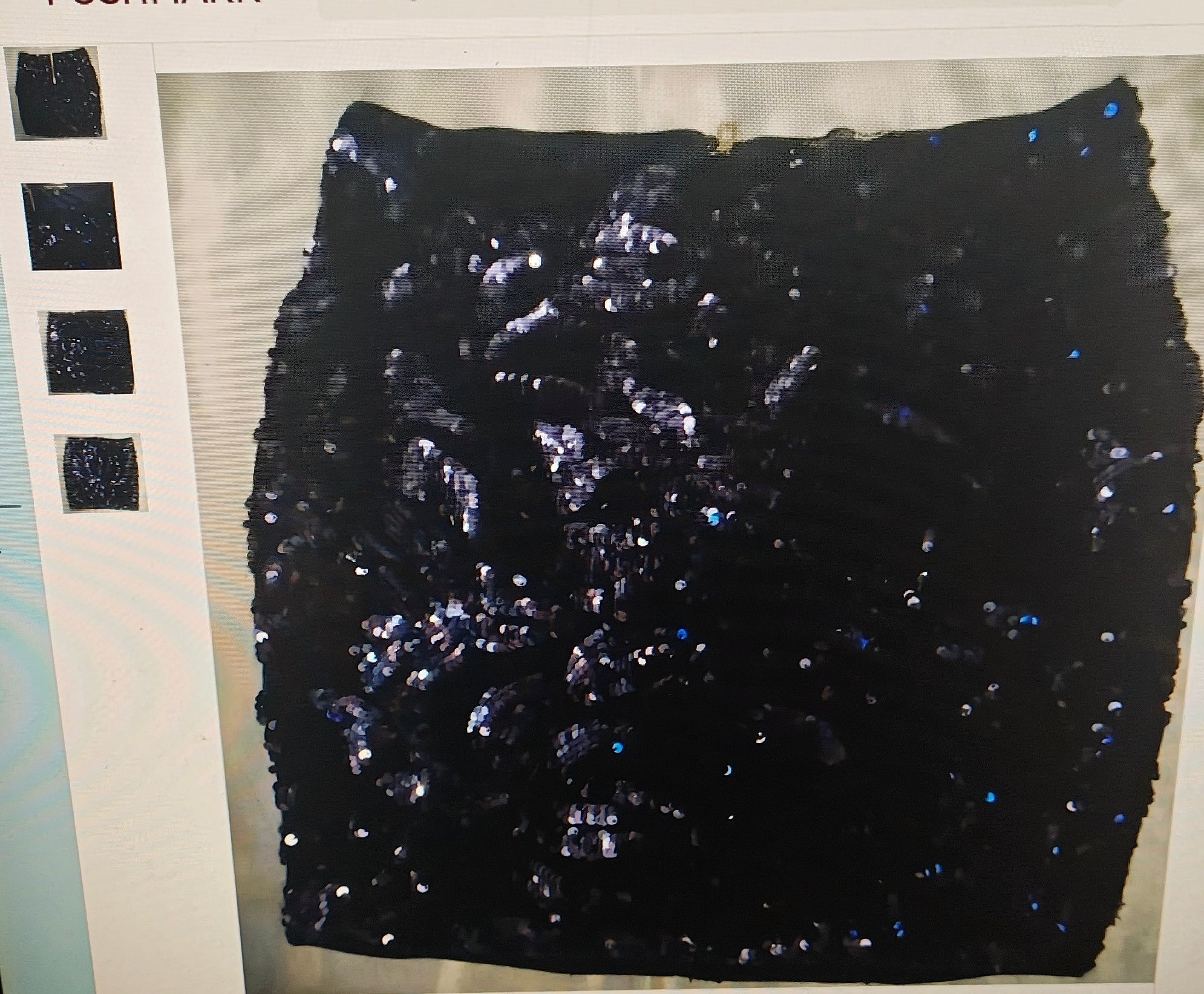 Black sequined fabric on a flat surface with a neutral background