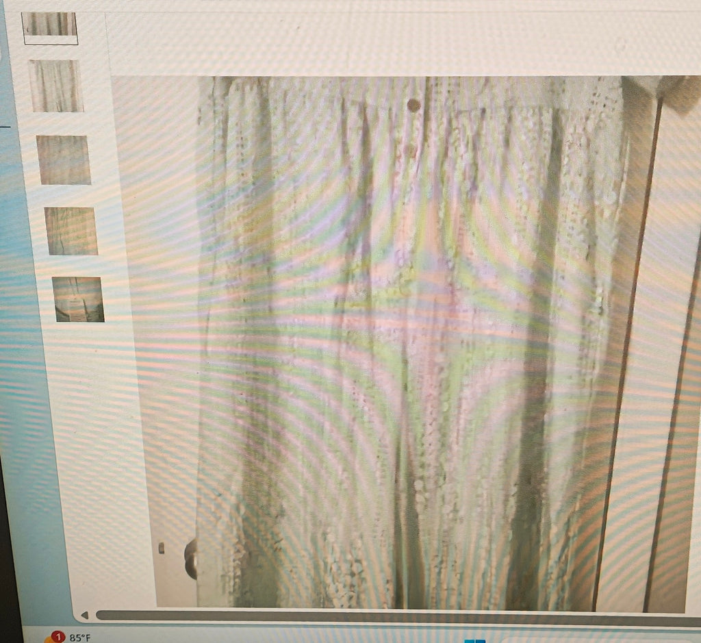 Computer screen displaying a blurred image of a curtain with a building in the background