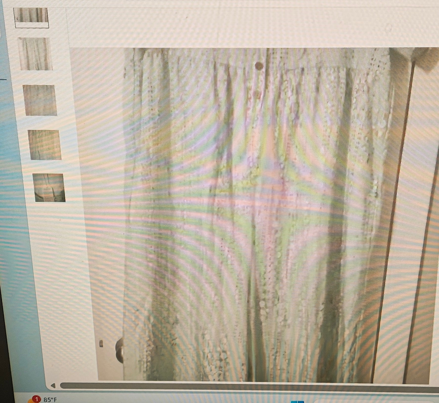Computer screen displaying a blurred image of a curtain with a building in the background