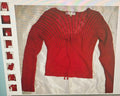 Red ribbed sweater with embellishments on a white background