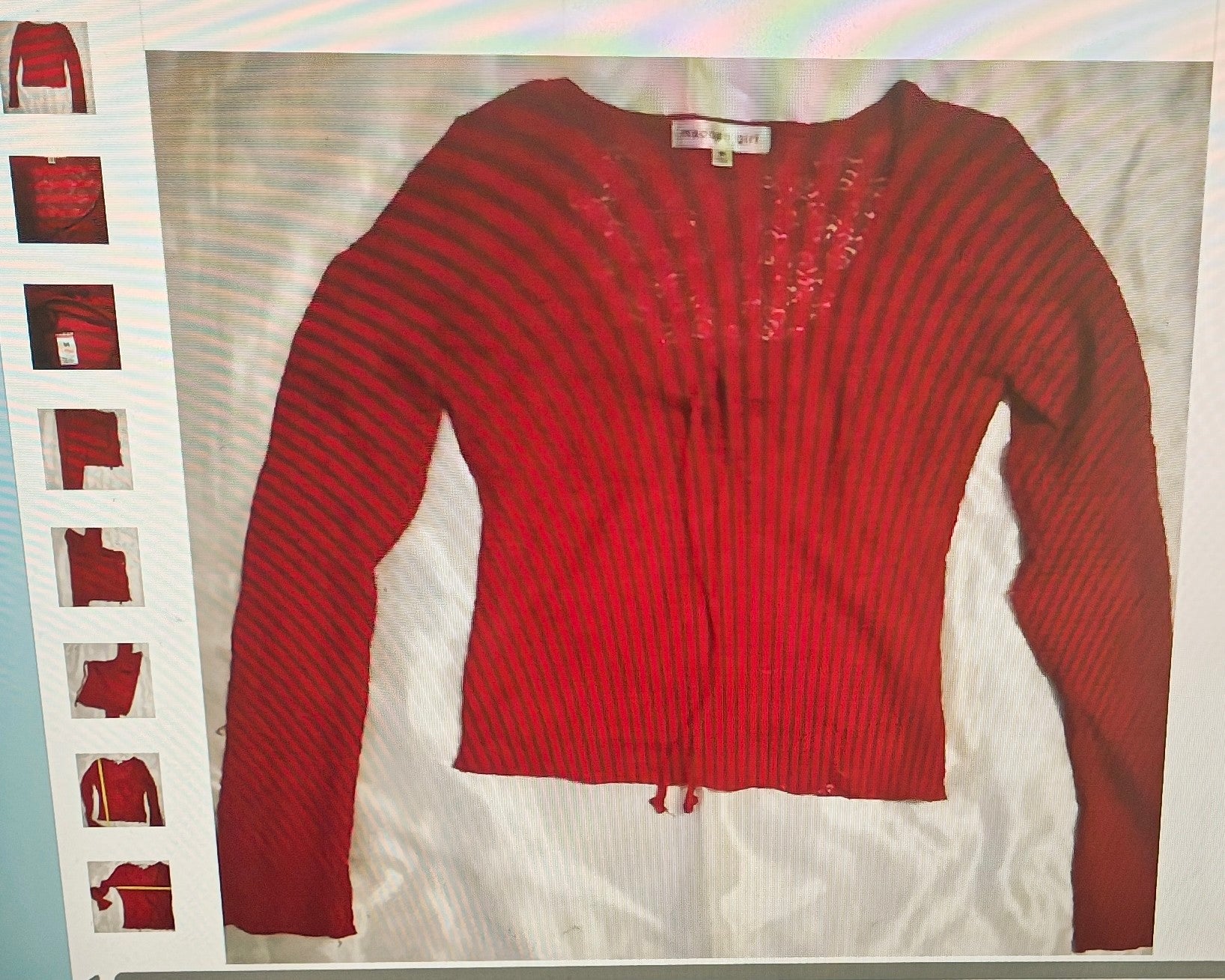Red ribbed sweater with embellishments on a white background