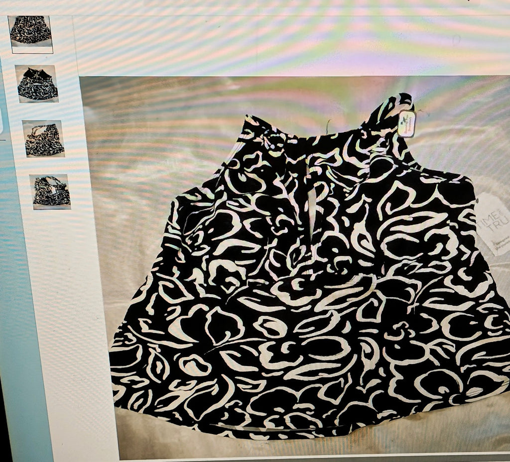 Black and white patterned top on a hanger with a blurred background