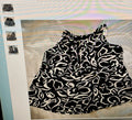 Black and white patterned top on a hanger with a blurred background