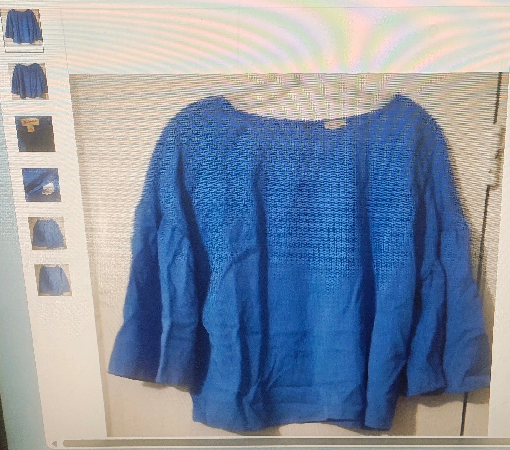 Blue sweater on a hanger with a white background