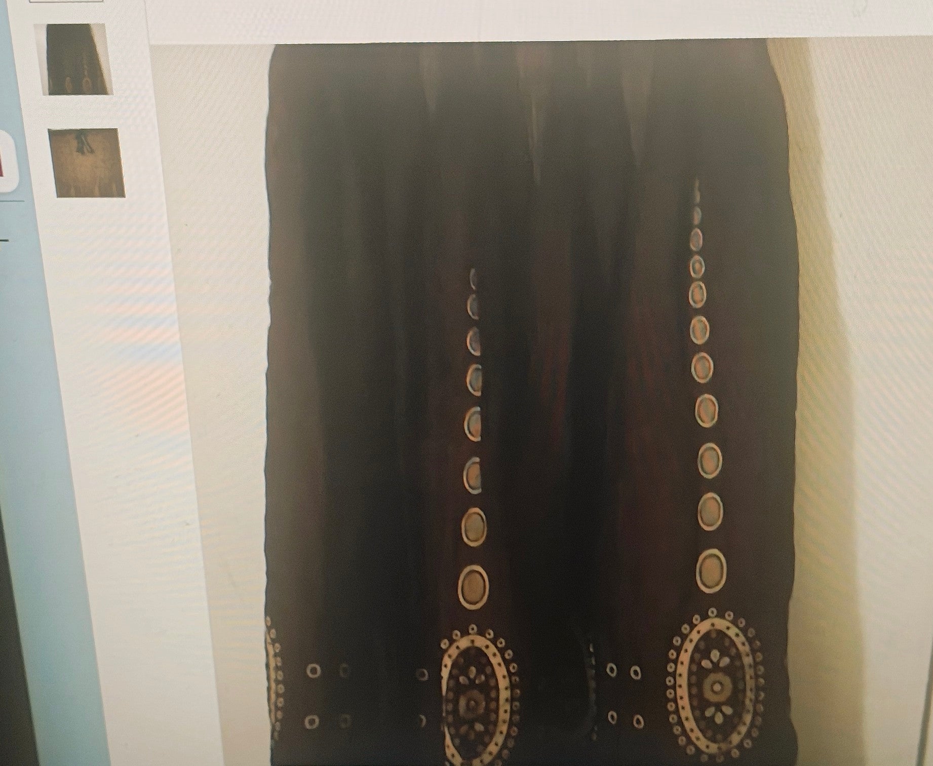 Black fabric with gold embroidery on a white background