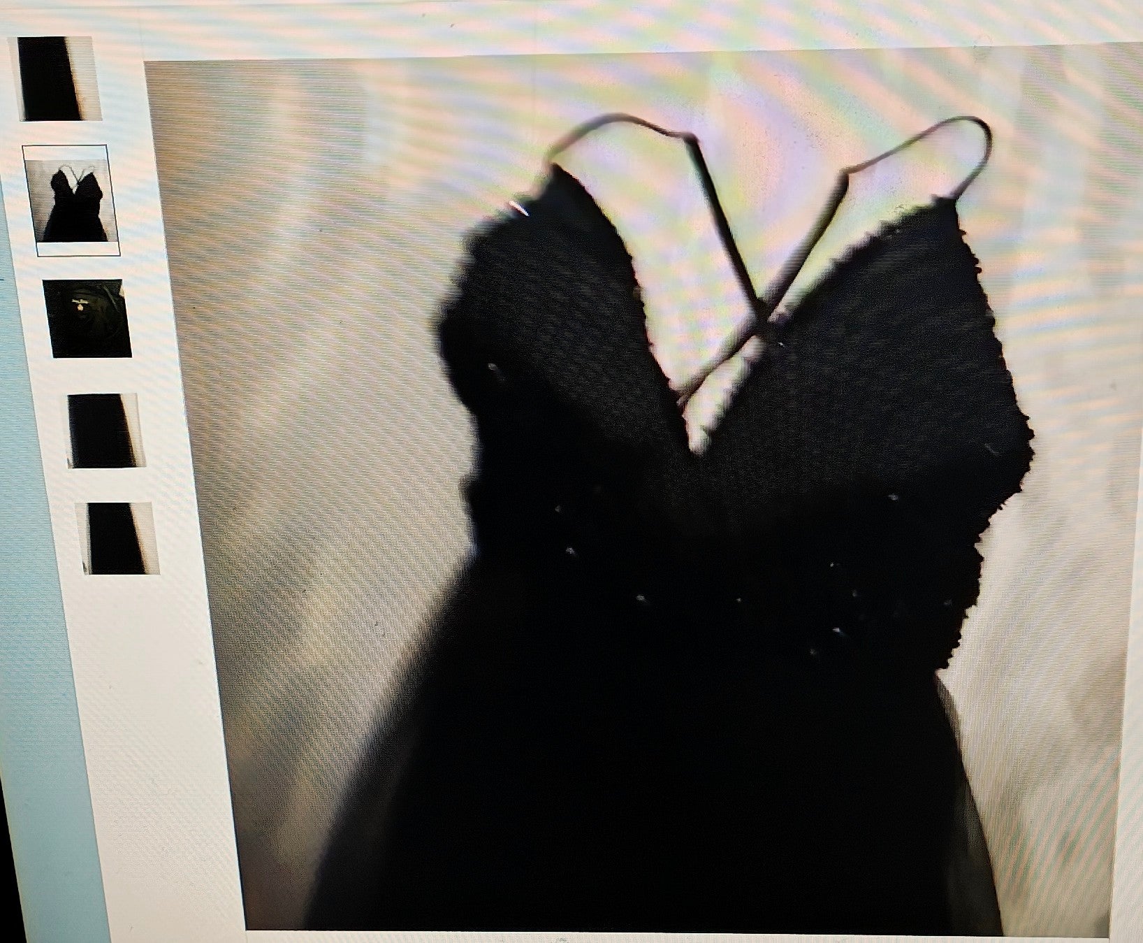 Black dress with thin straps on a textured beige background