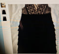 Black dress with patterned top on a textured surface