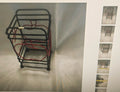 A black metal wire shopping cart organizer rack with red wire loops inside, shown on a light gray background with a vertical strip of smaller thumbnail views on the right.