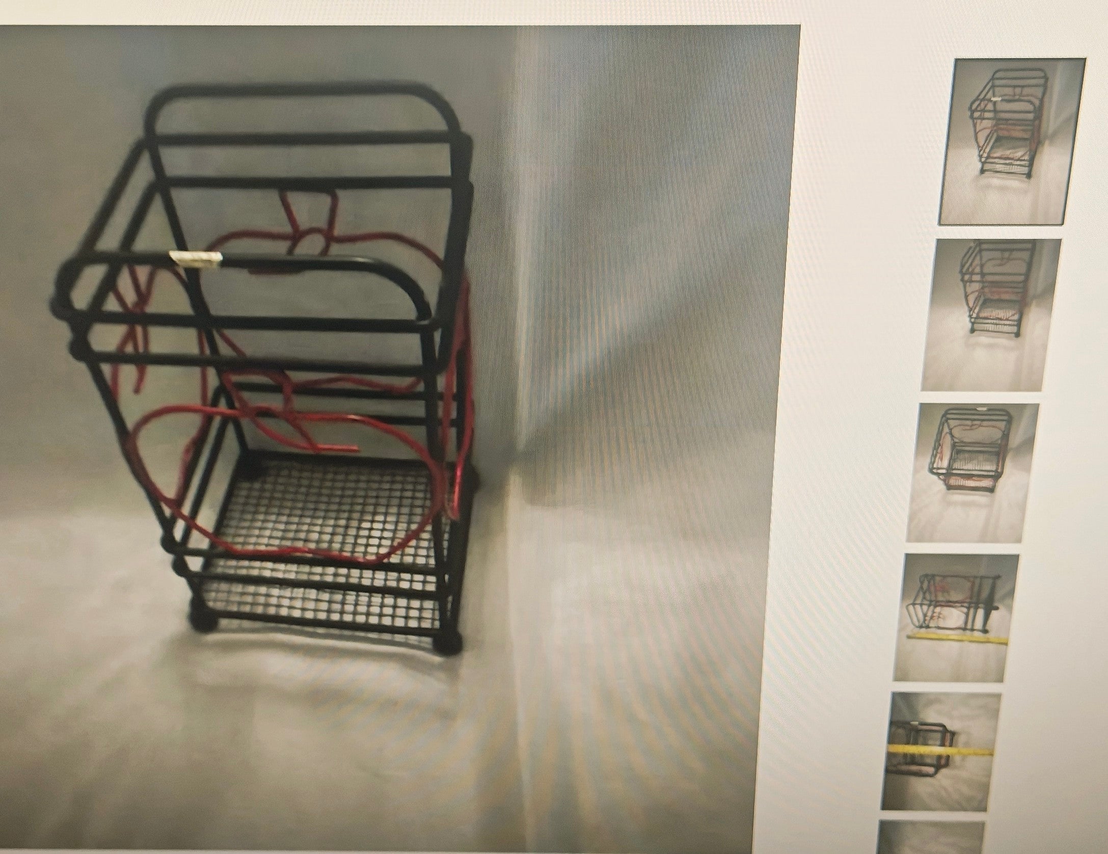 A black metal wire shopping cart organizer rack with red wire loops inside, shown on a light gray background with a vertical strip of smaller thumbnail views on the right.